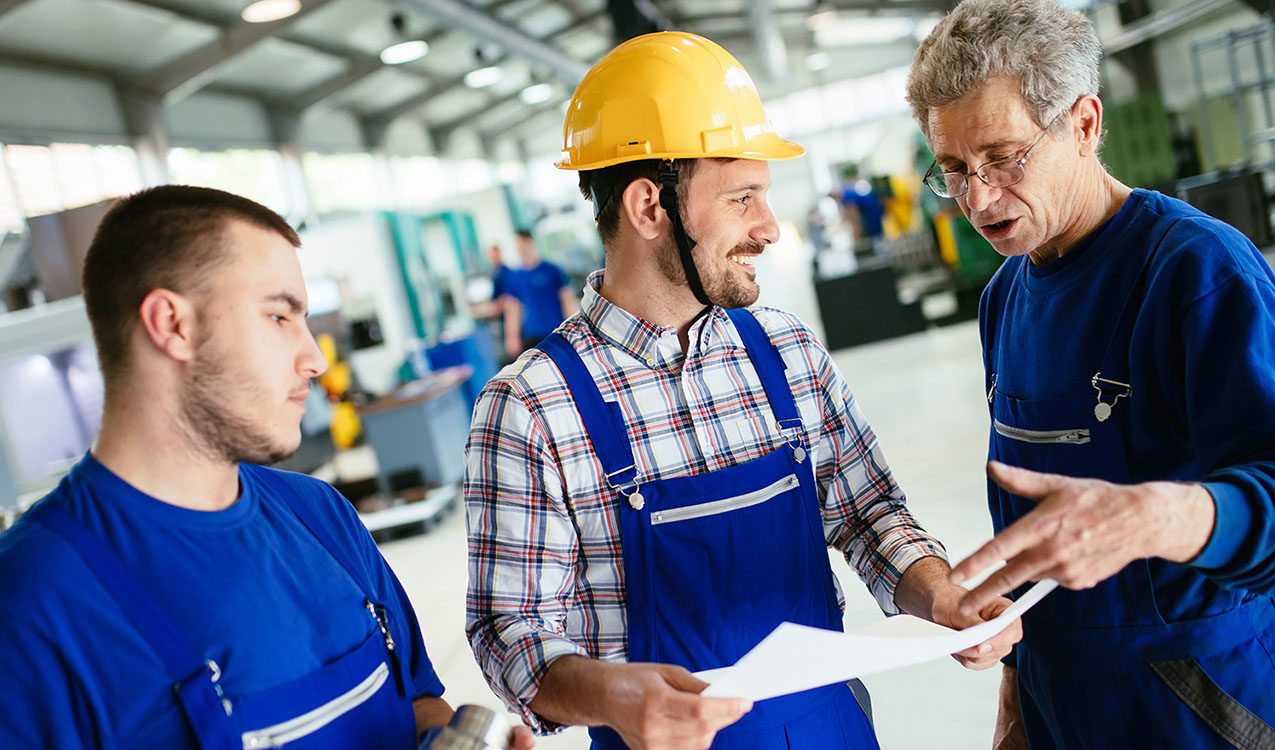 Engineer Teaching Apprentices To Use Computerized cnc metal processing machines