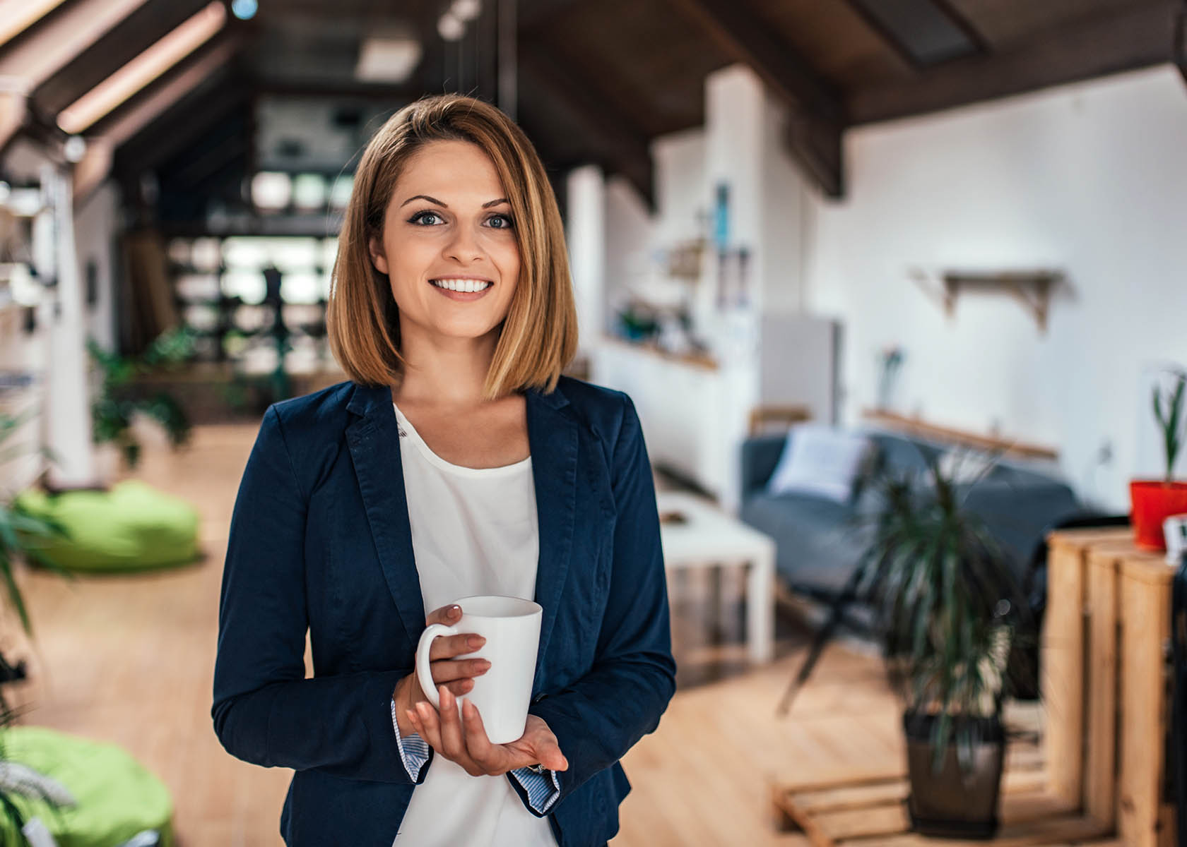 Portrait of a confident young woman holding a mug in a coworking