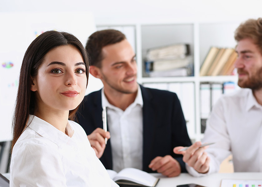 Beautiful smiling cheerful girl at workplace look