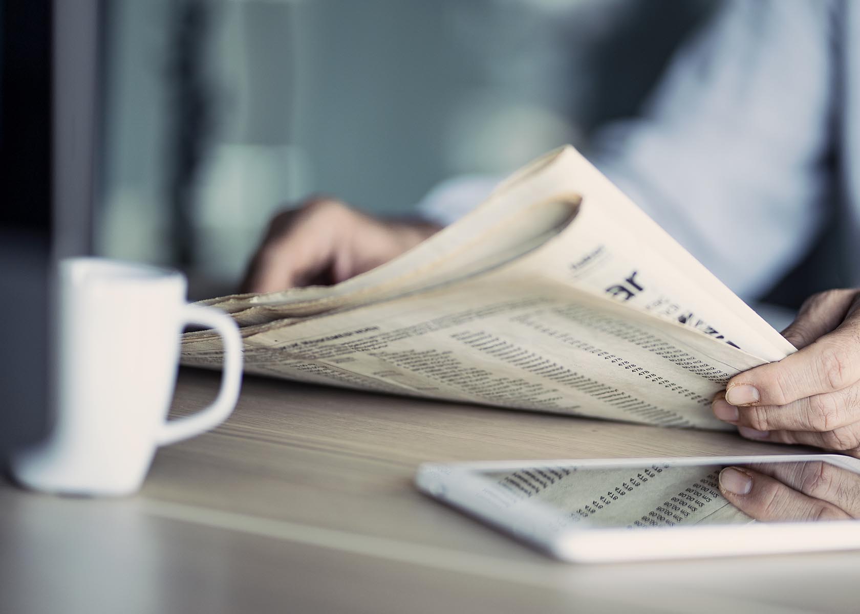 Businessman reading the newspaper on table